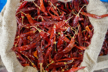 Lots of dried chilies in a sack. Red chili pepper, dried chillies in the traditional market