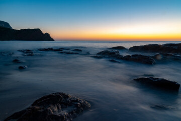 Ocean waves crash at a Pacific Ocean sunset