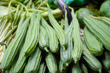 Pile of Angled Loofah Sponge gourd or Angled Gourd on Display at the traditional Farmer's Market. Ridge gourd vegetables