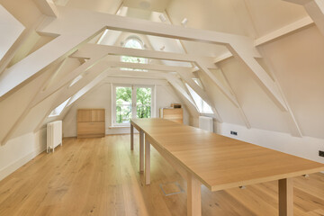 a kitchen and dining area in an attic style home with white walls, wood flooring and vaulteded...