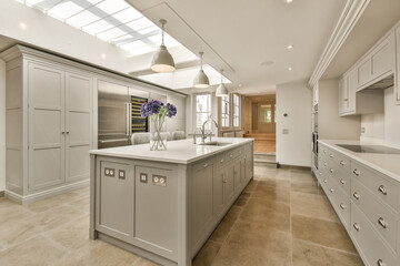 a kitchen with white cabinets and light gray countertops in the center of the room is an oven, dishwasher, sink