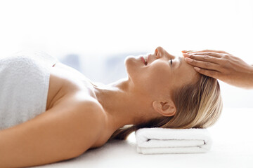 Obraz na płótnie Canvas Wellness Treatment. Middle aged woman getting acupressure head massage in spa salon