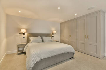 a bedroom with a bed and two lamps on either side of the headboards in front of the bed