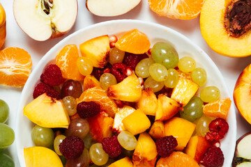 Fruit salad with sliced fruit, mixed grapes, raspberries, nectarines, tangerines and apples