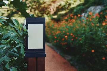 A lamppost on the railing of a footpath adorned with orange flowers