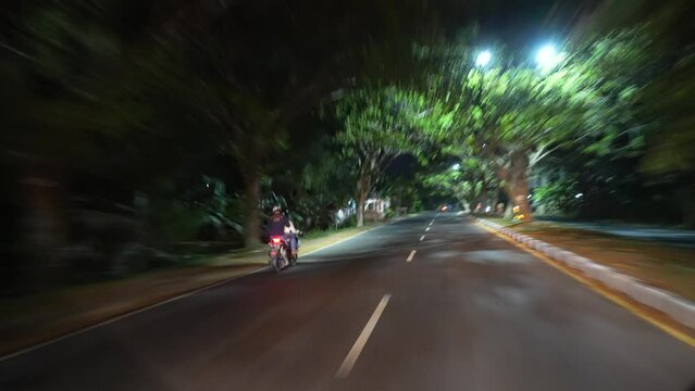 Motorbikes speeding up at night in Lombok, Indonesia