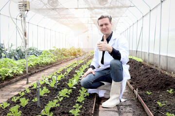 Botanist scientist man in lab coat working on experimental plant plots, male biological researcher...