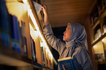 Happily young muslim woman enjoying books at the library. library concept