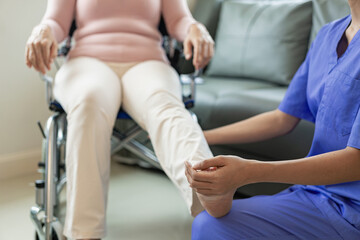 Obraz premium Elderly female patient with Asian female physical therapist holding her arm for physical therapy Rehabilitate weak muscles. A patient appears intent on doing this exercise in a hospital examination ro