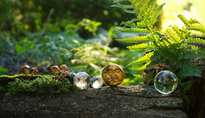 moon amulet and crystal balls on tree stump in forest, abstract natural background. esoteric spiritual ritual, wiccan magic, witchcraft. fairytale, mystery atmosphere. moon esbat, harvest moon symbol