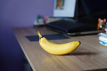 A beautiful tasty and fresh yellow banana on the table. A concept for healthy eating and fruit. Meal and snack while working in the office.