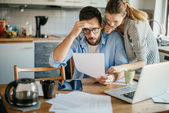 Stressed young couple doing financials in the kitchen