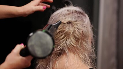 A woman uses a blow dryer to dry her hair. High quality 4k footage