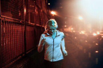 Young fit woman jogging on the street at night