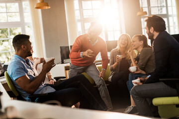 Young and diverse group of colleagues having a coffee break together in the computer office
