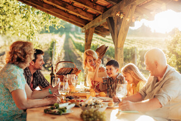 Multigenerational family having lunch in a gazebo on the vineyard