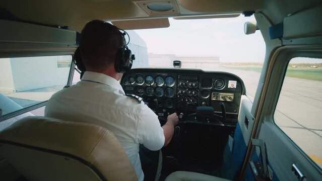 The pilot in the cockpit starts the engine of the small plane, and prepares for takeoff. Propeller Spin, plane is ready for takeoff.