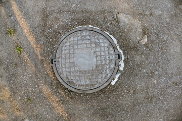 Geometric Shape Covering Manhole Lid on Asphalt Road