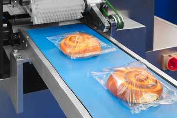 Conveyor Belt Food. Factory for the production of bun, bread.  Production line with packaging. Food products  in plastic packaging on the conveyor. food production concept