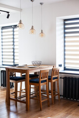 Wooden high bar table and chairs at dining space. Modern kitchen interior. Vertical image.