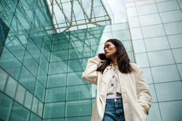 Portrait of woman talking by phone in a cosmopolitan environment.
