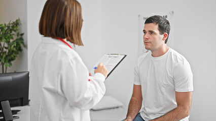 Doctor and patient having medical consultation taking notes at the clinic