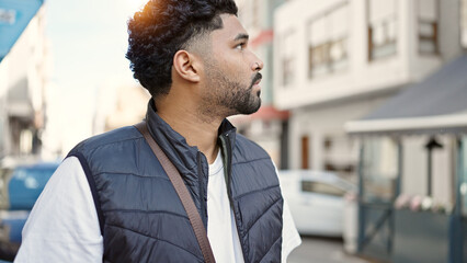 Naklejka premium African american man looking to the side with serious expression at street