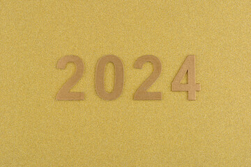 Fototapeta na wymiar Números de año nuevo de 2024 sobre fondo dorado de fantasía