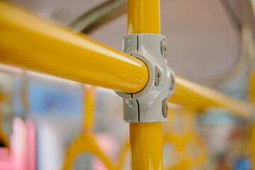 Yellow metal railings in a public transport, closeup of photo