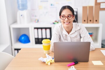 Young beautiful hispanic woman business worker using laptop drinking coffee at office