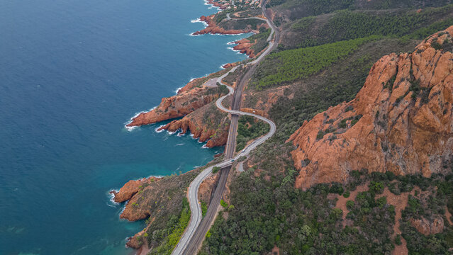 Aerial view of the Massif de L'Esterel and a beautiful winding road over the cliffs falling into the Mediterranean Sea. French Riviera. Cote d'Azur