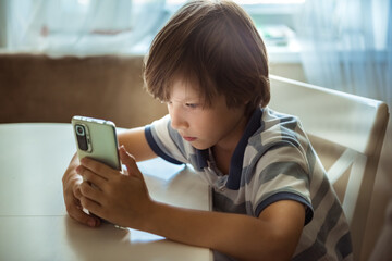Cute child using smart phones, playing games. Children's screen addiction and parent control...