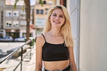 Young blonde woman smiling confident standing at street