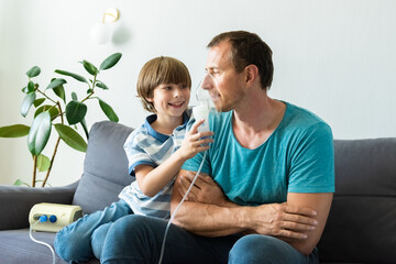 Portrait of father and son using domestic nebulizer