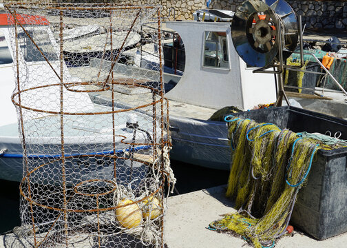 Fishing boats and fishing equipment on the dock in the small harbor