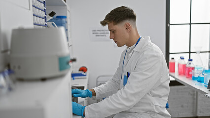 In the heart of the lab, young, handsome caucasian man-scientist expertly typing away on his computer, 100% focused on his on-going experiments and analysis.
