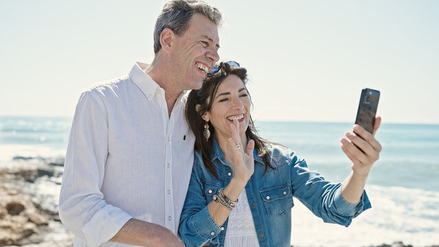 Senior man and woman couple smiling confident having video call at seaside