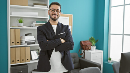 Young arab man business worker standing with arms crossed gesture smiling at the office
