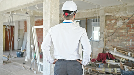 Fototapeta premium Young hispanic man architect standing backwards at construction site