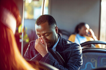 Frustrated young businessman commuting to work on the bus