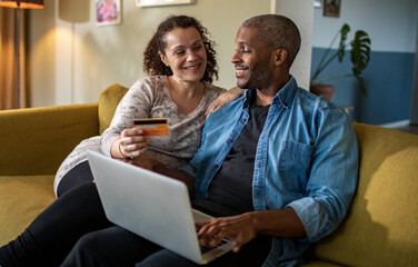 Mixed couple online shopping together on the laptop at home