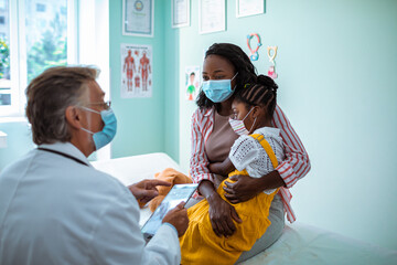 Young mother consulting a pediatrician about her daughter at the clinic