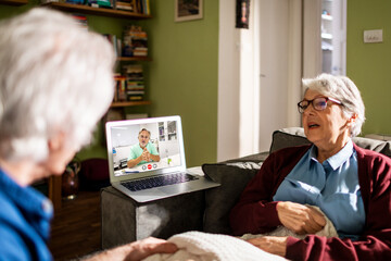 Senior Caucasian couple consulting their doctor on a video call on the laptop at home