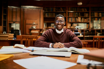 Smiling portrait of a young student in a university library