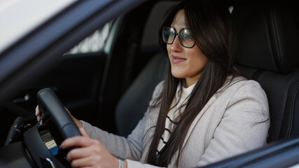 Young beautiful hispanic woman smiling confident driving car at street