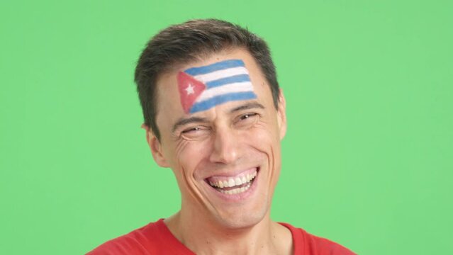 Man with a cuban flag painted on the face smiling