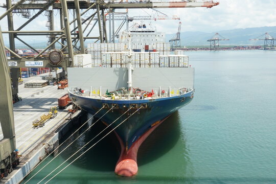 Kingston, Jamaica - 07 08 2023: Fully loaded vessel with reefer containers viewed from bow and forward mooring station is alongside in port of Kingstone under gantry cranes during cargo operation.