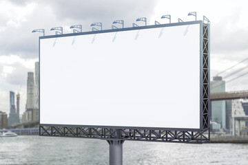 Fototapeta premium Blank white horizontal billboard on skyline background at daytime, perspective view. Mock up, advertising concept