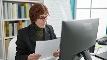 Mature hispanic woman university teacher on video call reading documents at library university