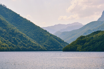 Calm tranquil lake water in the canyon between green mountains. Beautiful nature landscapes. Montenegro